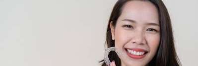 A woman holding her Invisalign tray | dentist Chesterfield, MO