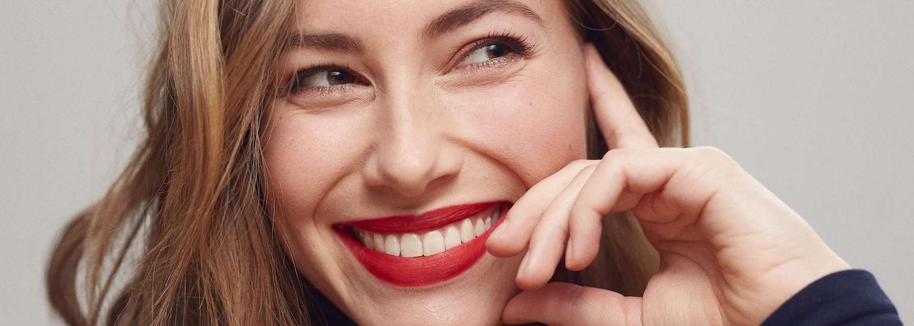 A smiling woman in front of a white background | chesterfield dentist