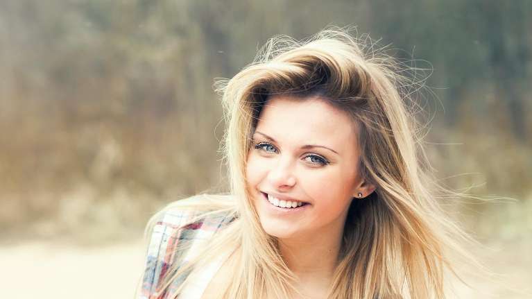 A woman smiling outdoors | dentist Chesterfield Missouri