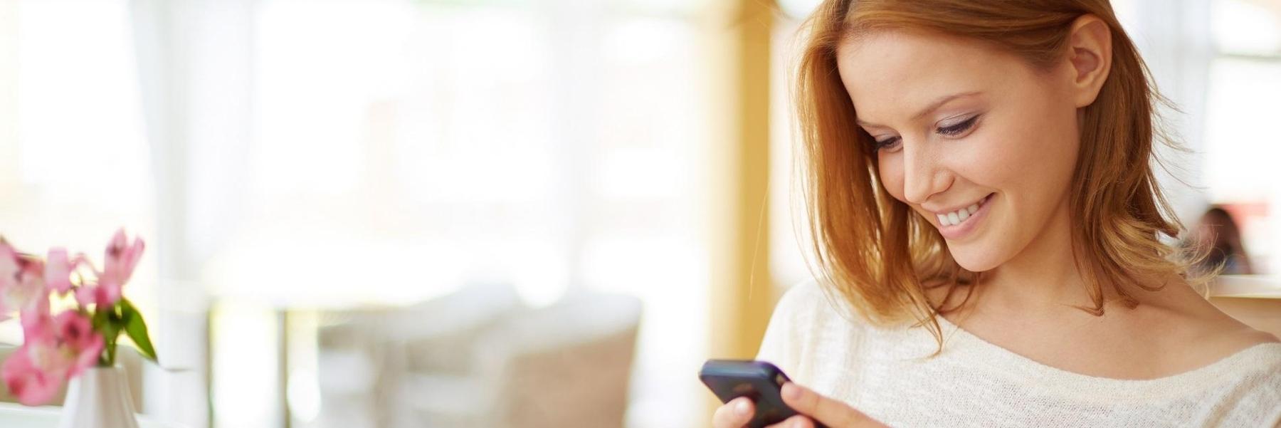 woman smiling looking at phone